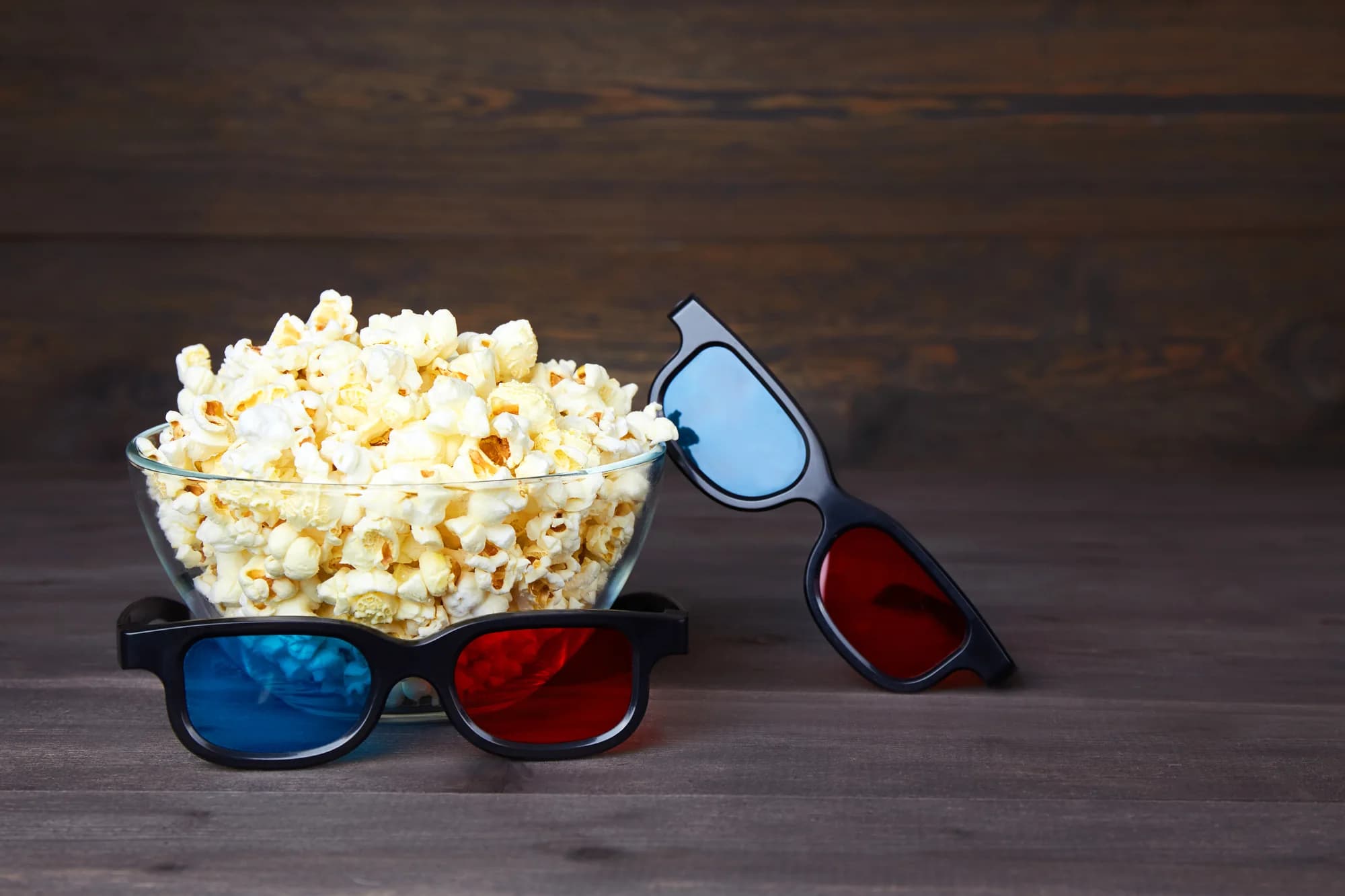 Popcorn und 3D-Brillen auf einem Holztisch