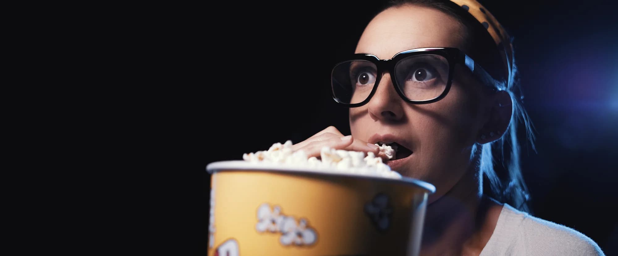 Zuschauerin mit 3D-Brille und Popcorn, gebannt vom Film
